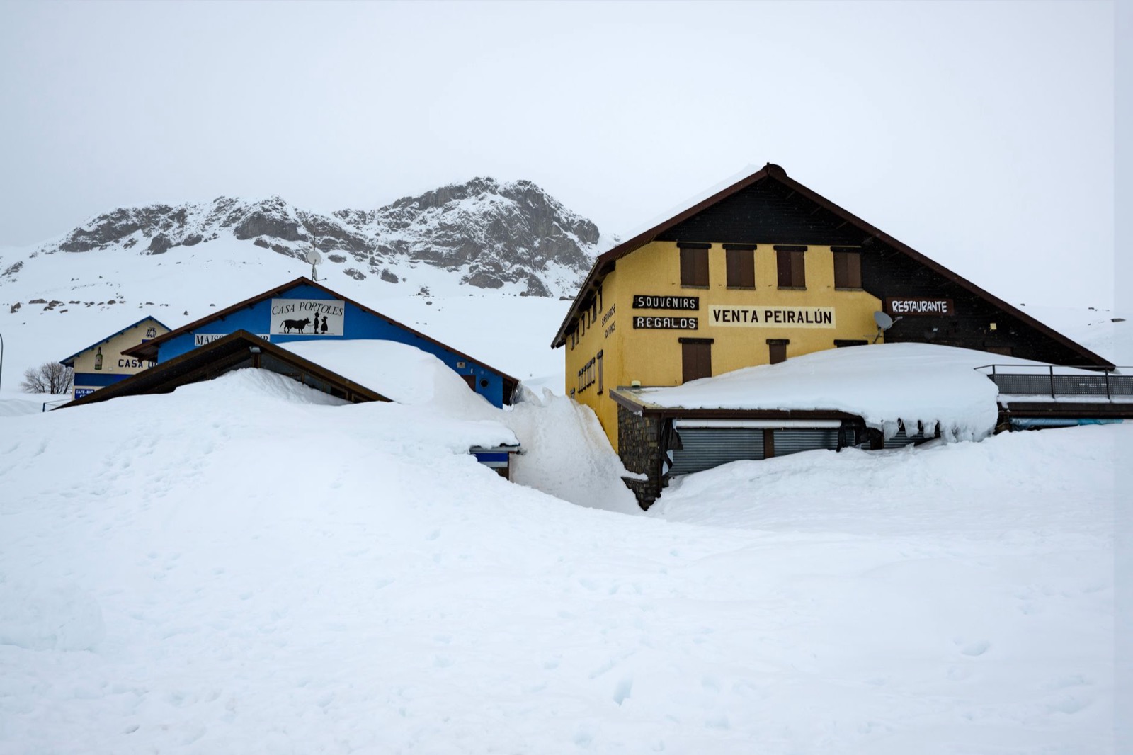 Buildings and mountain slopes covered by snow in Andorra