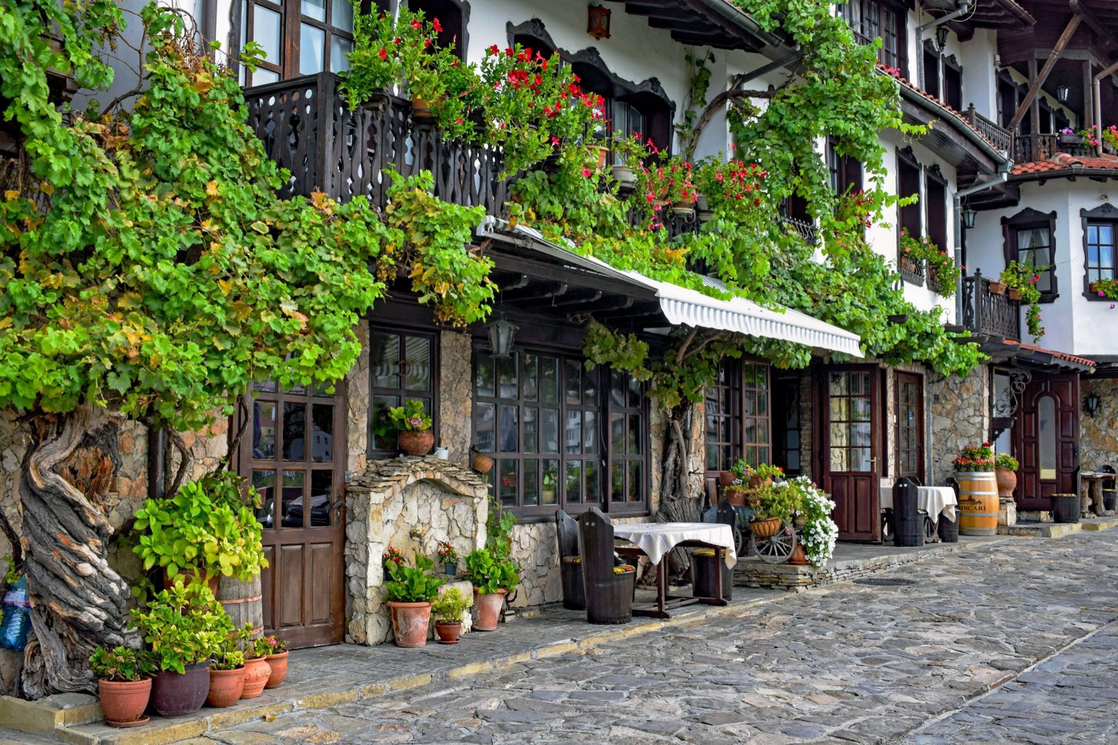 Stone and timber houses on a cobbled street in a Bulgarian revival period village