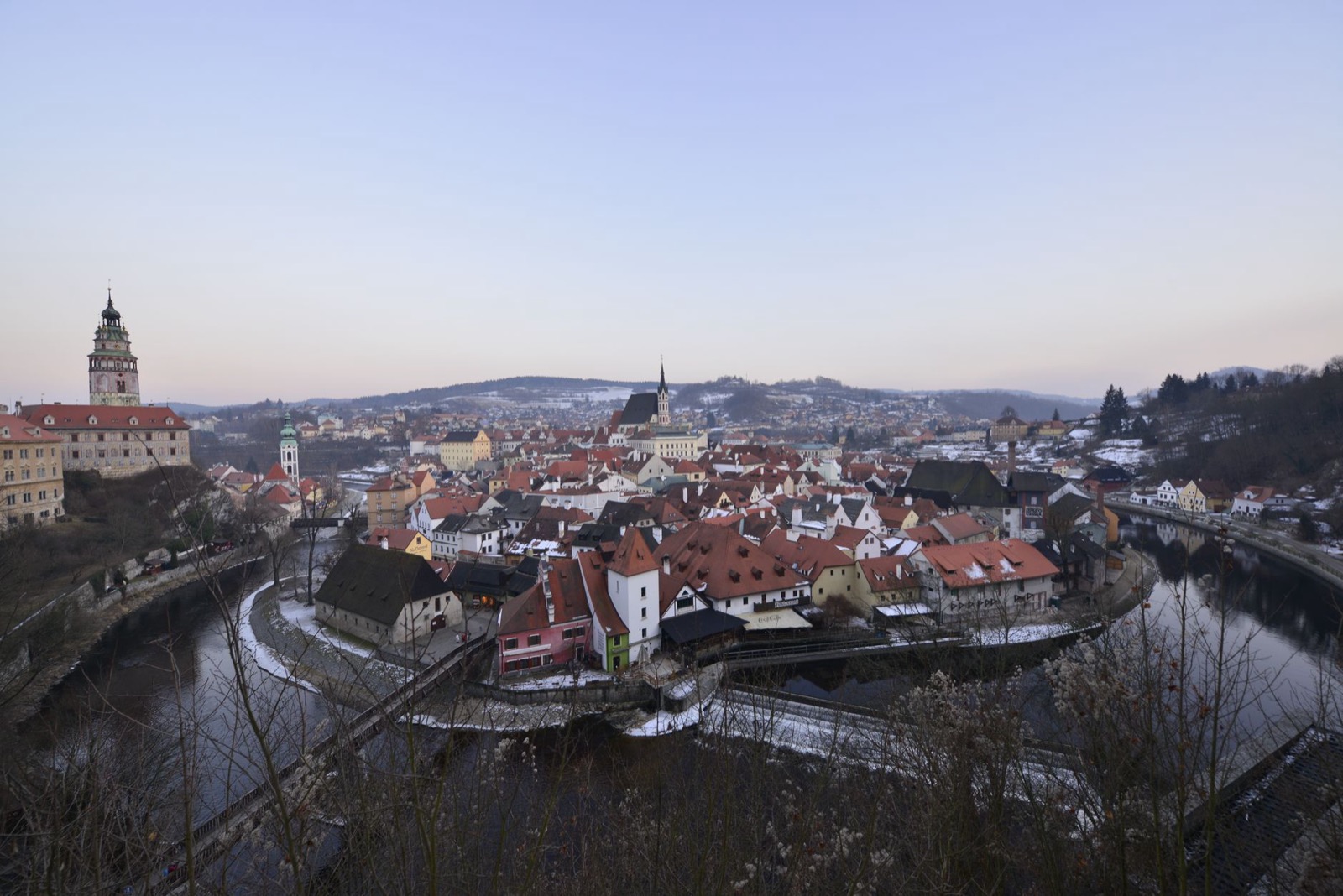 The old town of Cesky Krumlov wrapped in a bend of the Vltava, its castle tower above red roofs