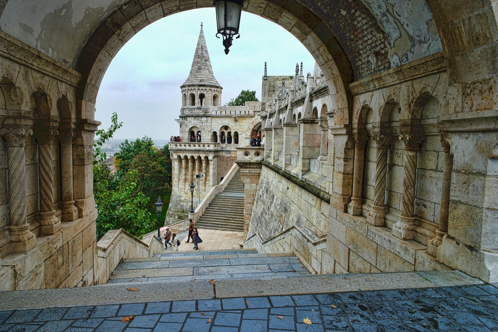 The white turret and stairs of the Fisherman's Bastion seen through a stone arch
