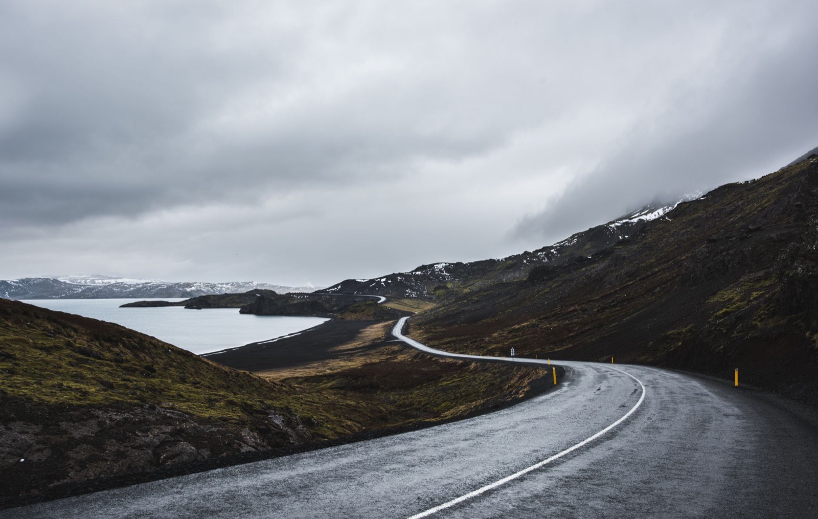 Rain and low cloud sweeping across an Icelandic road below dark mountains
