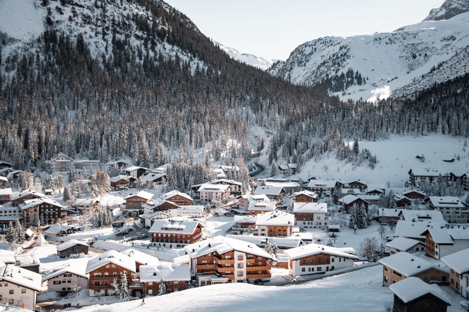 Snow covered chalets and ski slopes in a high alpine bowl