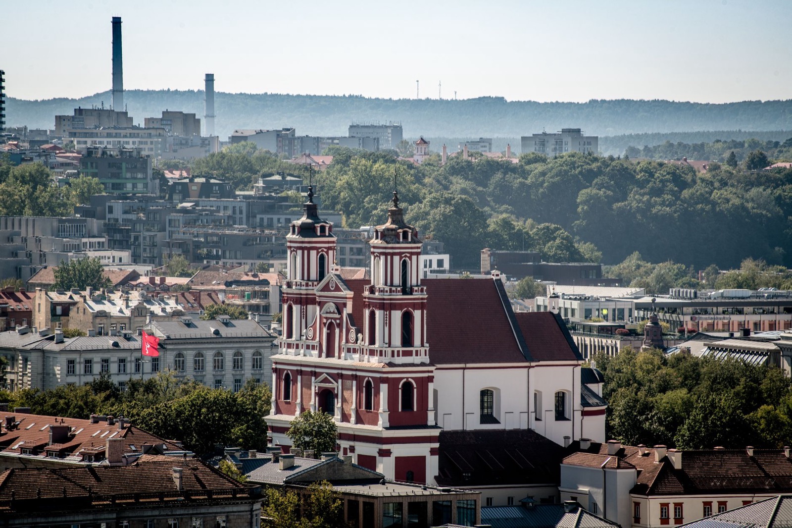 A red and white baroque church rising above the rooftops of Vilnius