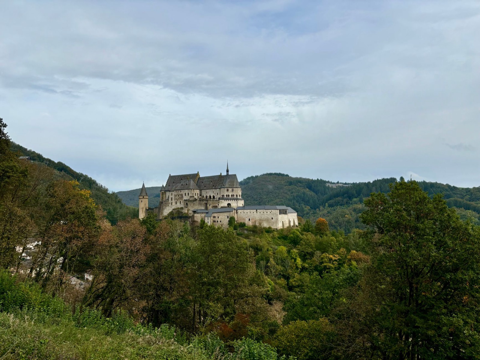 Vianden castle on its ridge above a wooded valley and slate-roofed town