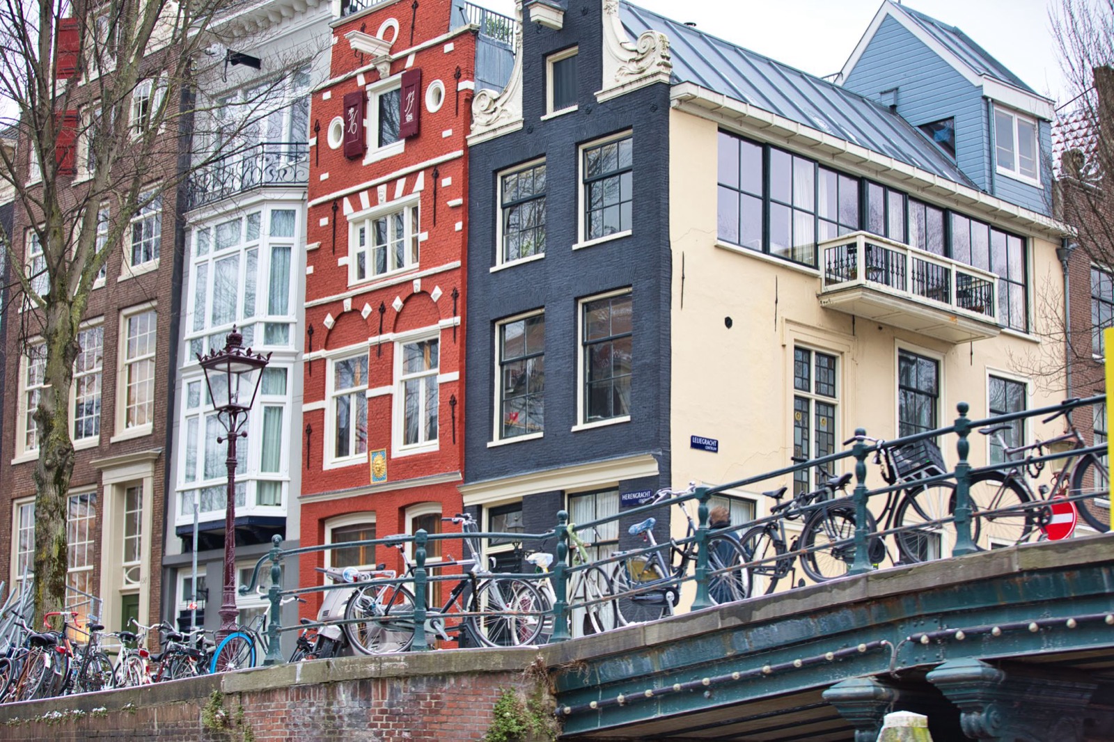 Bicycles chained to the railing of a canal bridge in a Dutch city
