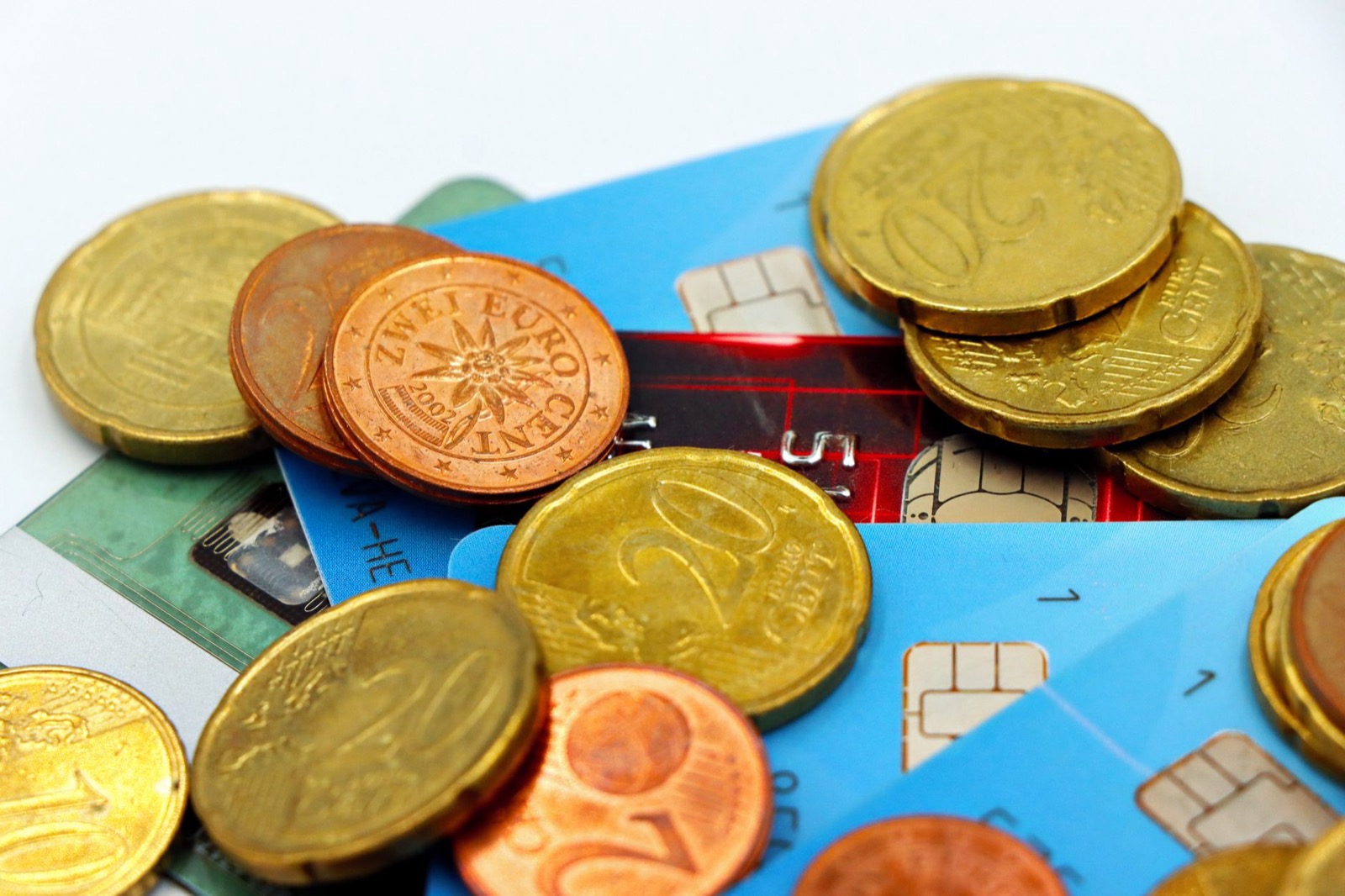 Euro coins beside bank cards