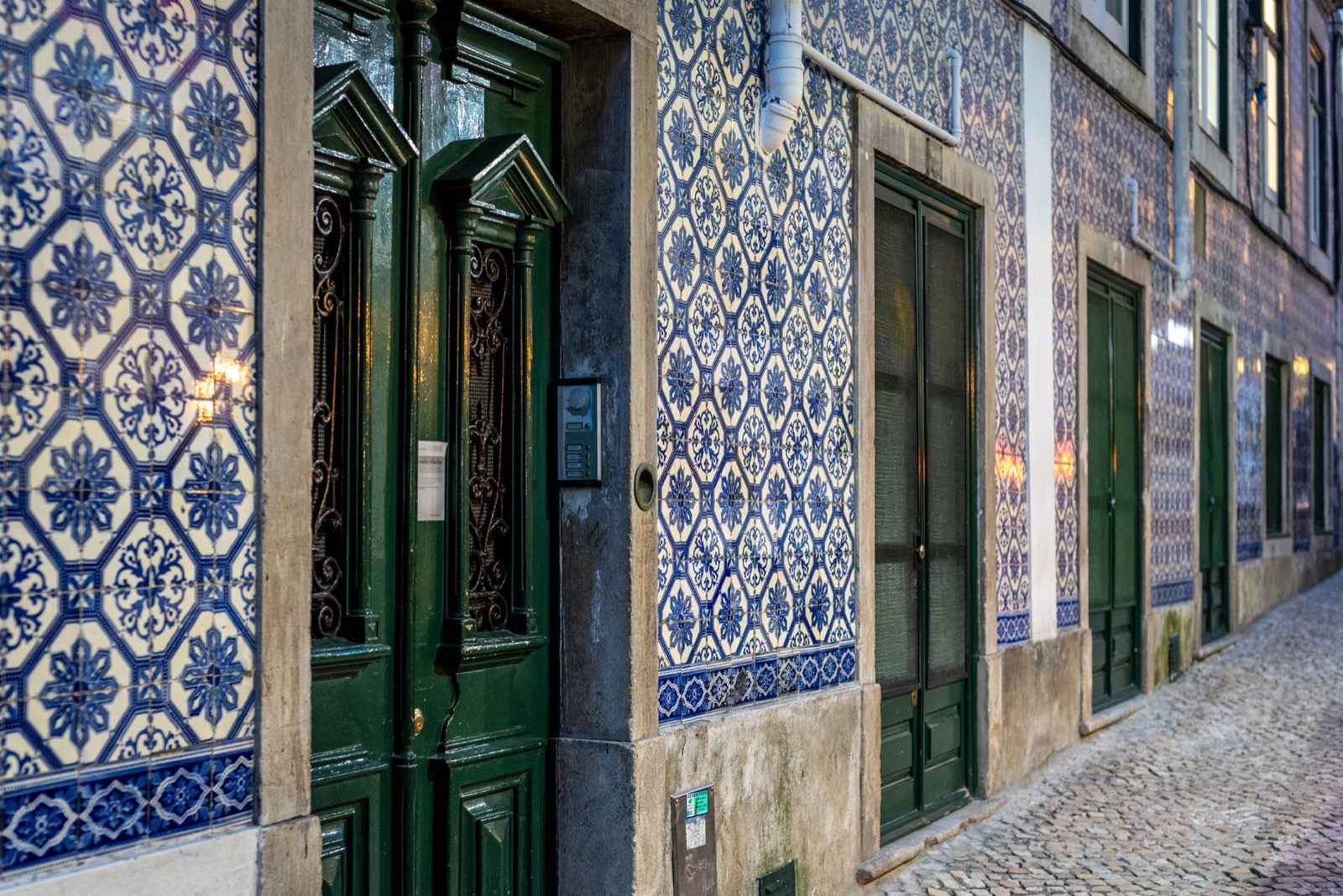 Blue and white azulejo tiles on buildings along a Portuguese street