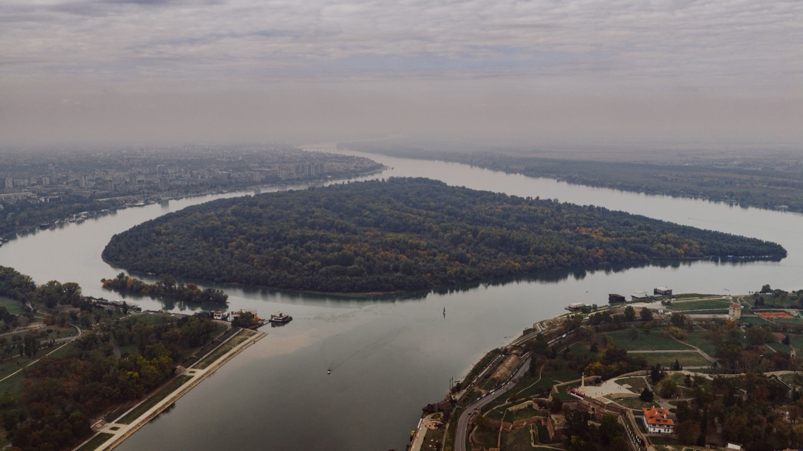 An aerial view of the wooded island where the Sava meets the Danube at Belgrade, with the fortress on the right bank