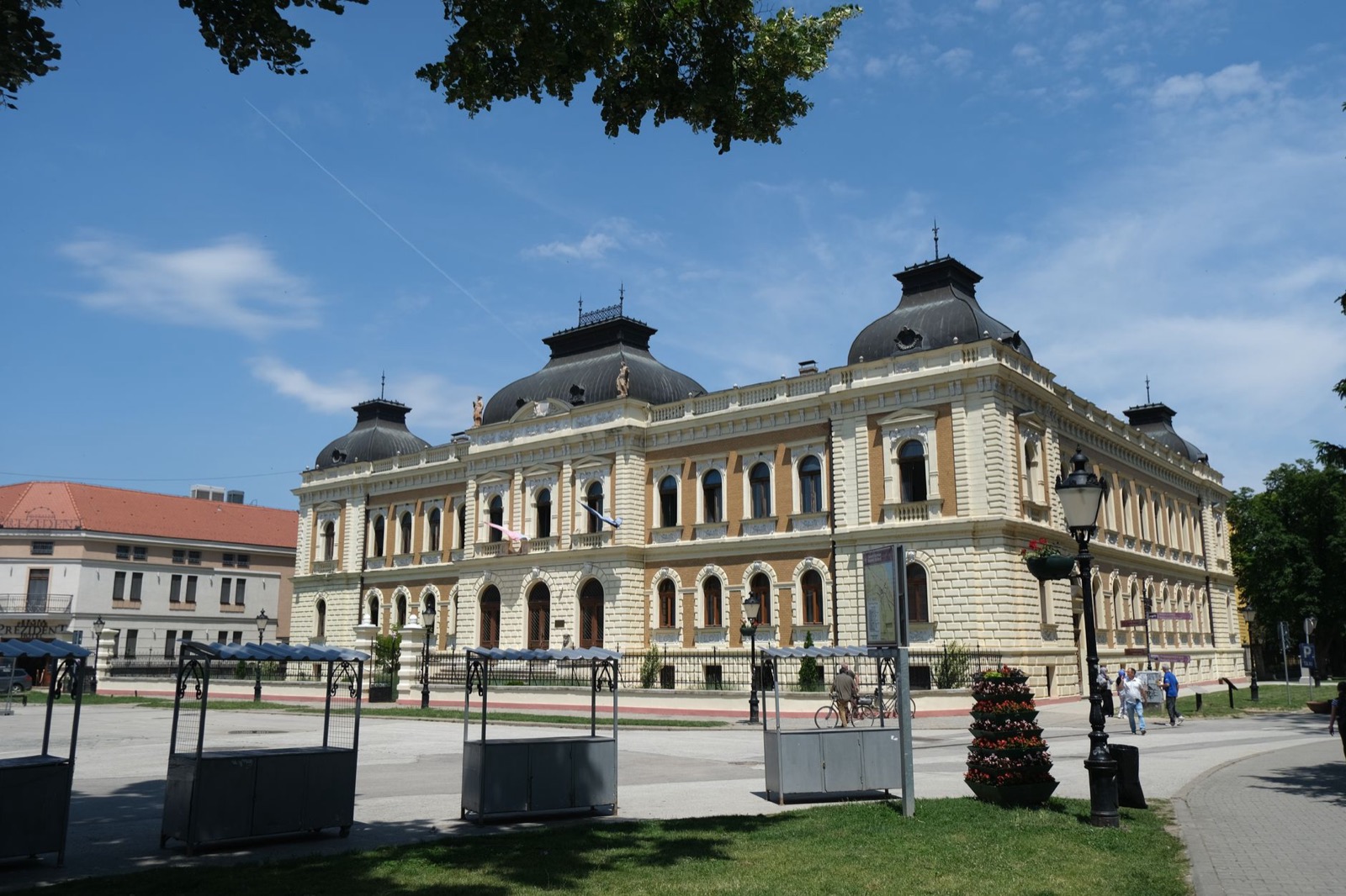 A grand nineteenth century public building with domed corner pavilions on a town square