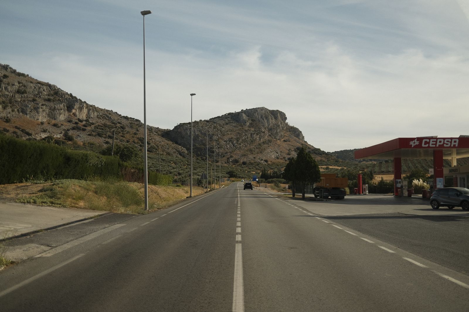 An empty Spanish road running through dry hills