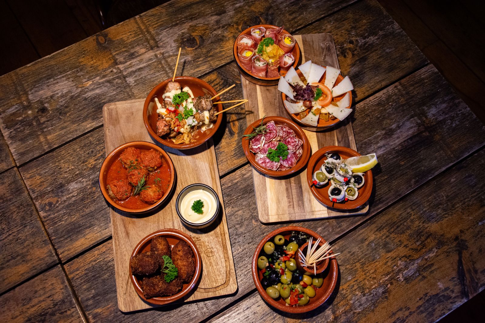 Small ceramic dishes of tapas on a wooden table