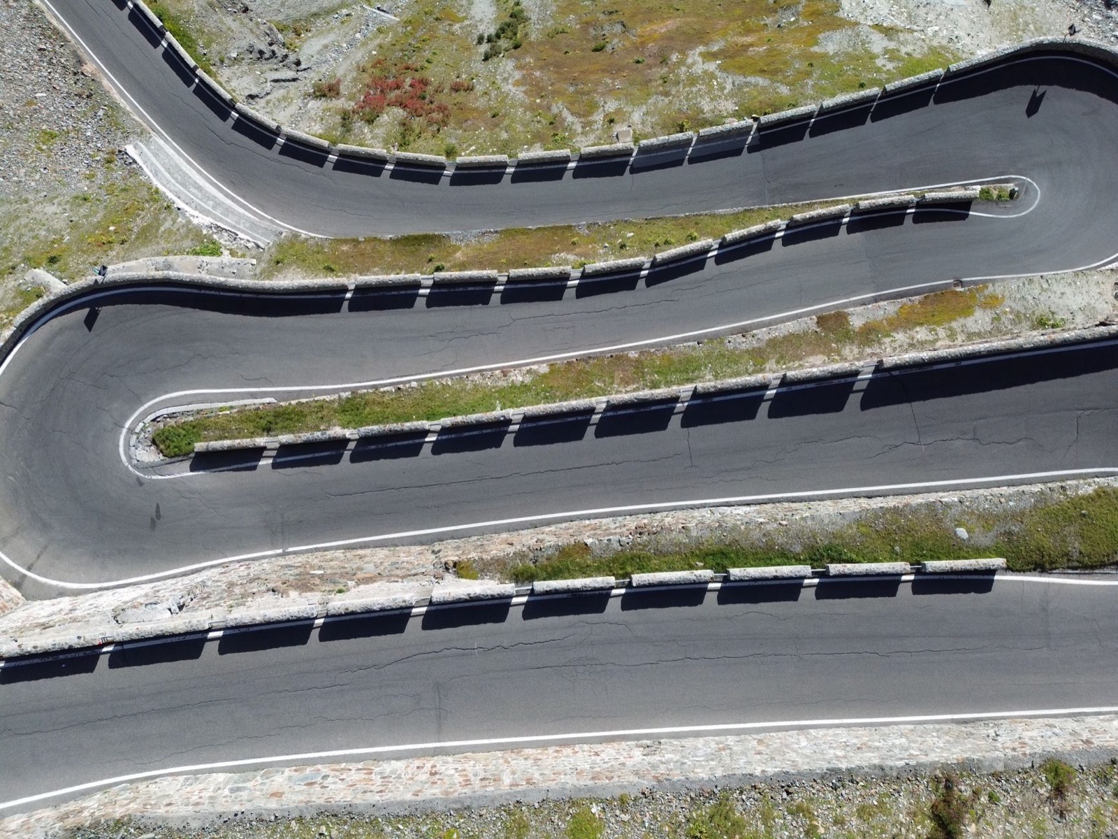 Hairpin bends of a pass road stacked above one another, seen from directly overhead