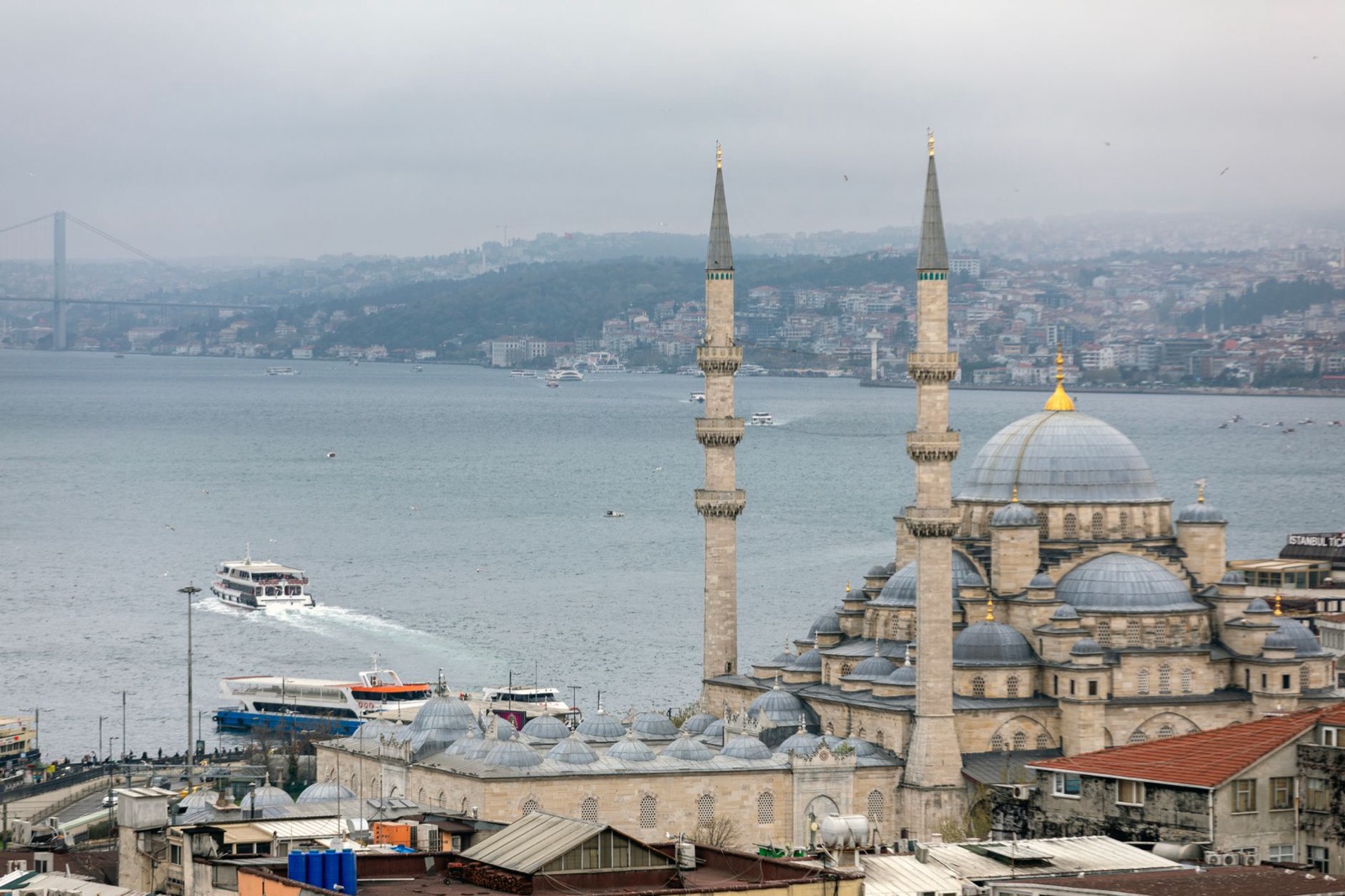Istanbul's skyline of domes and minarets above the Bosphorus with a ferry passing