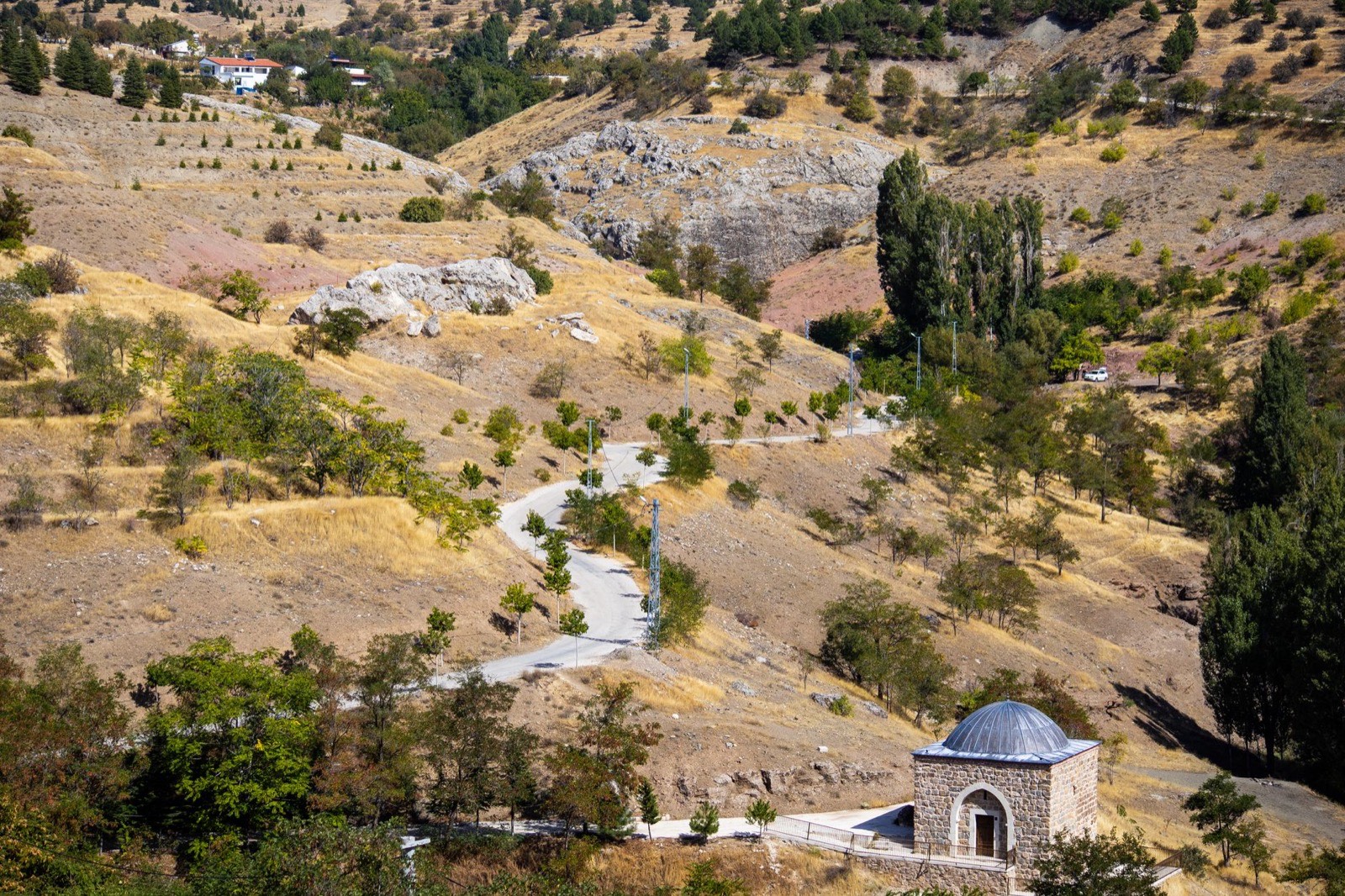 An empty two-lane road running straight across bare hills in central Anatolia